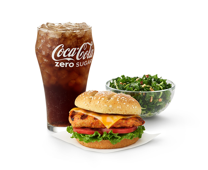  Grilled Spicy Deluxe Sandwich with a side of a Kale Crunch Salad and a glass of Coca-Cola Zero Sugar